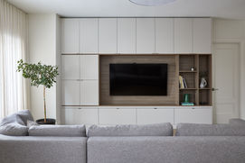 TV mounted in a living room facing a sectional