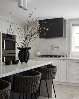Minimal black and white kitchen with black range hood and large kitchen island