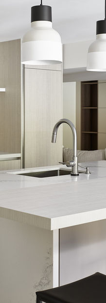 White quartz kitchen island with white and black pendant lights