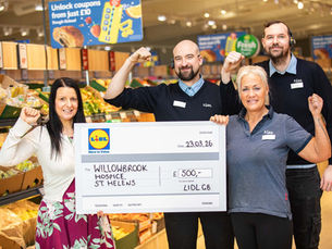 Lidl staff holding a large cheque to donate to their chosen charity.