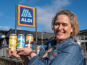 A photo of Fiona MacEachern, Managing Director of Loch Lomond Brewery, holding 3 cans of their beer.