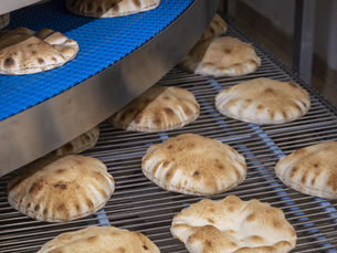 Authentic bakery flatbreads cooking in an oven.