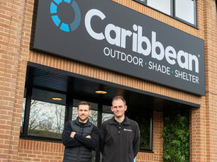 Stuart and Brad Dantzic standing together outside their newly redesigned company logo and ethos.