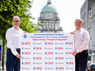 Two leading men holding up a board promoting Digital Product Passport Programme.