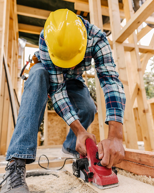 construction-worker-with-hard-hat-sanding-down-wood-piece.jpg