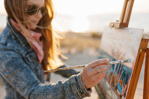 fine artist Larissa Flynn painting on beach