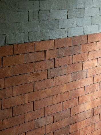 Interior wall with green slate and brick tile installed with Millennium Slate's Velcro backed building products