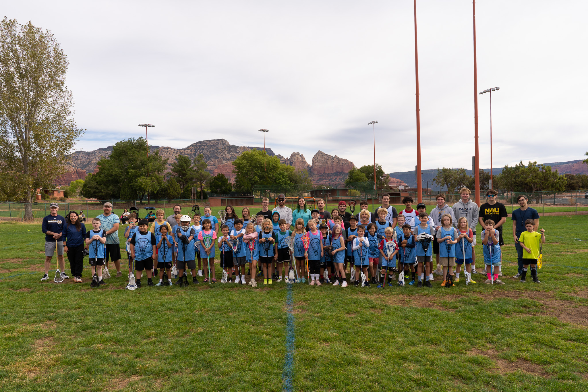 NAYL players coaches and volunteers gathered on the field with Sedona red rocks behind them