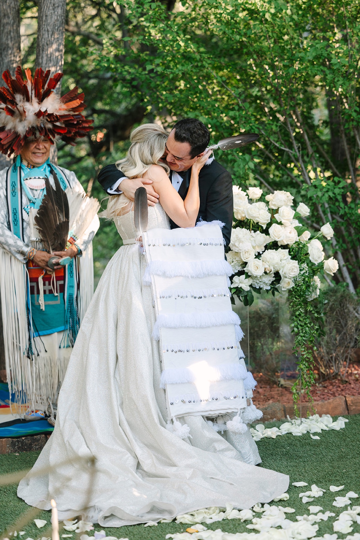 A bride and groom embracing during an intimate outdoor wedding ceremony in Sedona