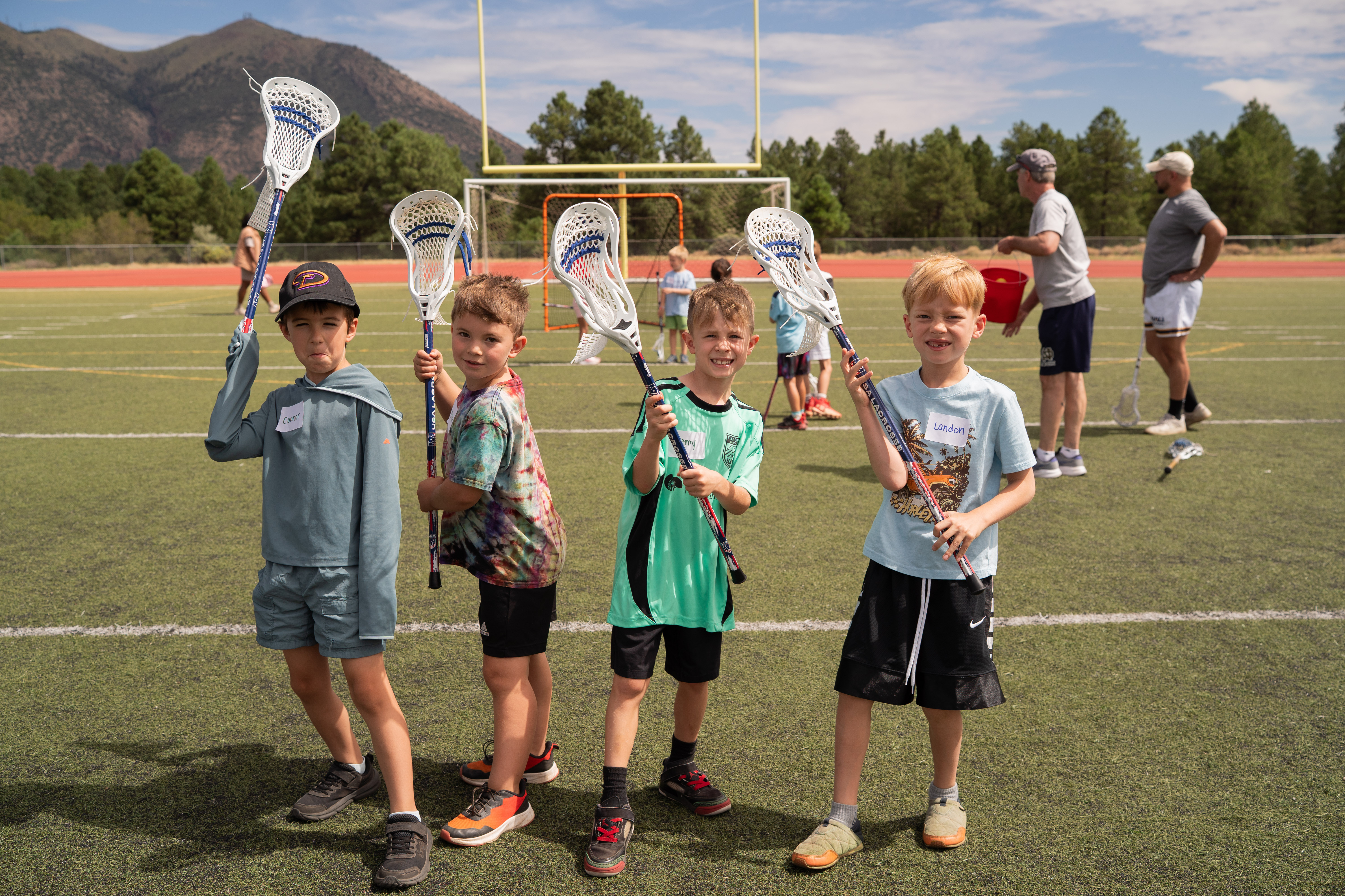 Northern Arizona children smiling with lacrosse sticks at a beginner clinic
