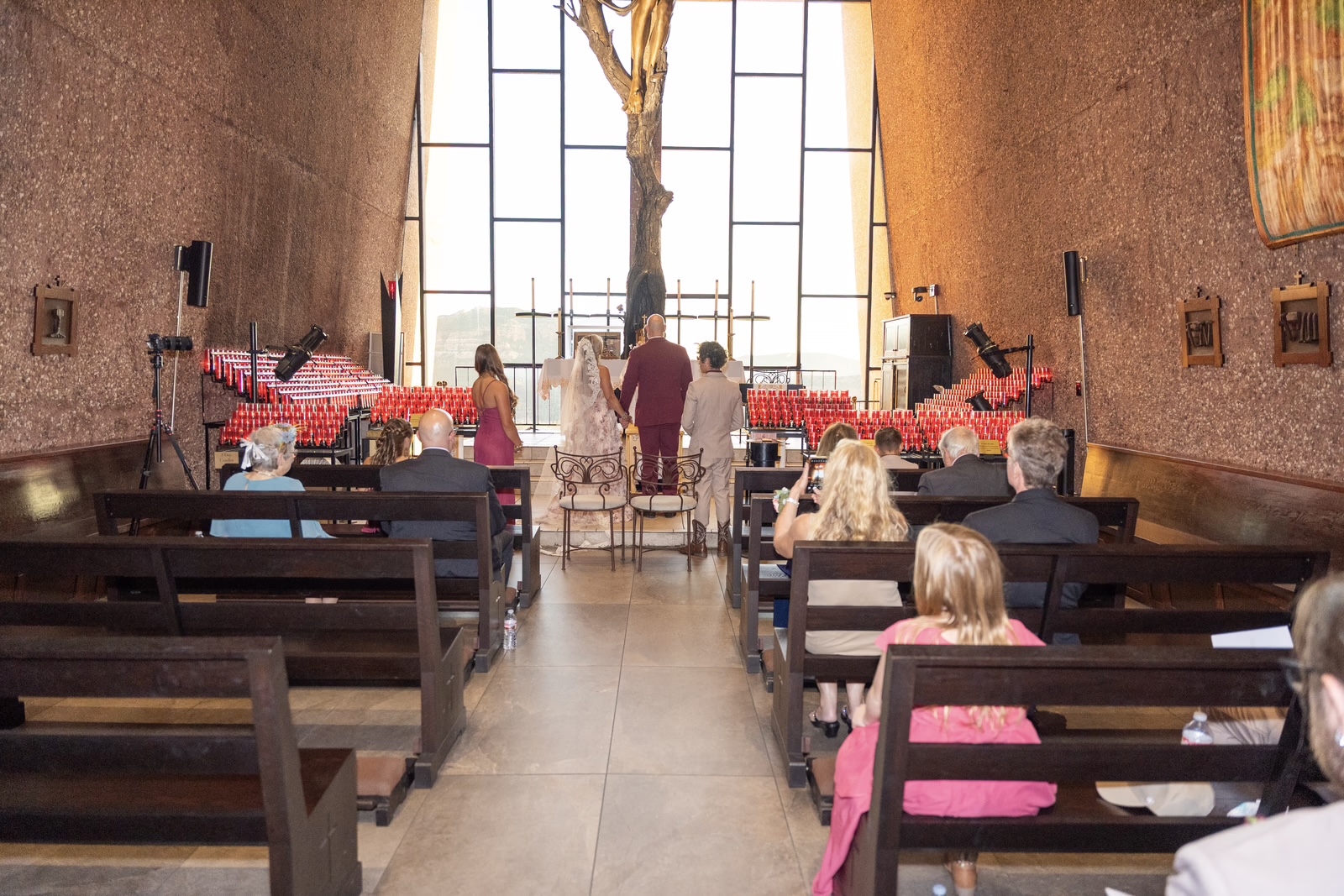 An intimate wedding ceremony with seated guests inside Sedona’s Chapel of the Holy Cross