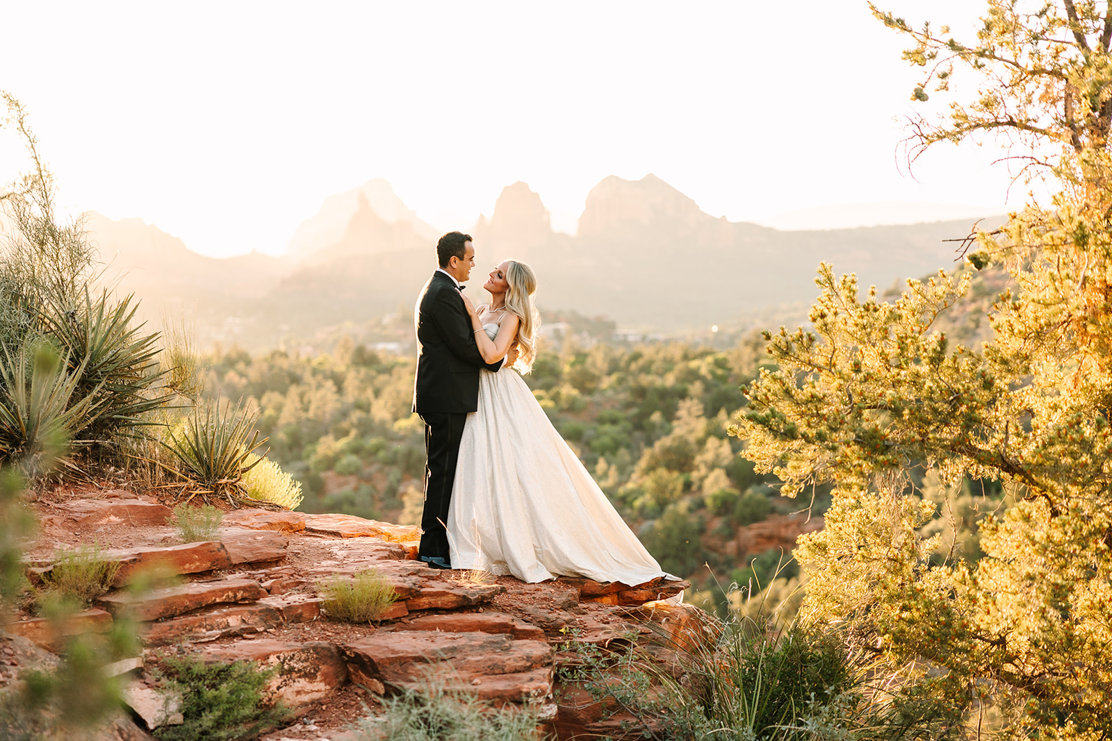 Newlyweds in warm light with Sedona red-rock views