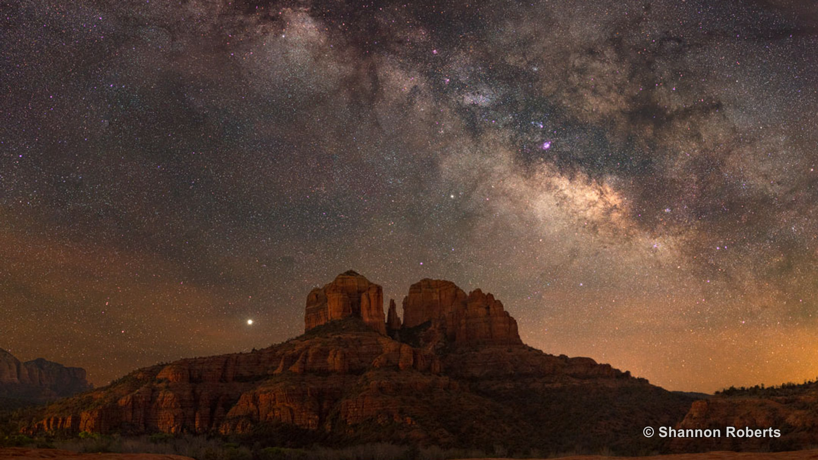 The Milky Way arching above Cathedral Rock in Sedona at night.