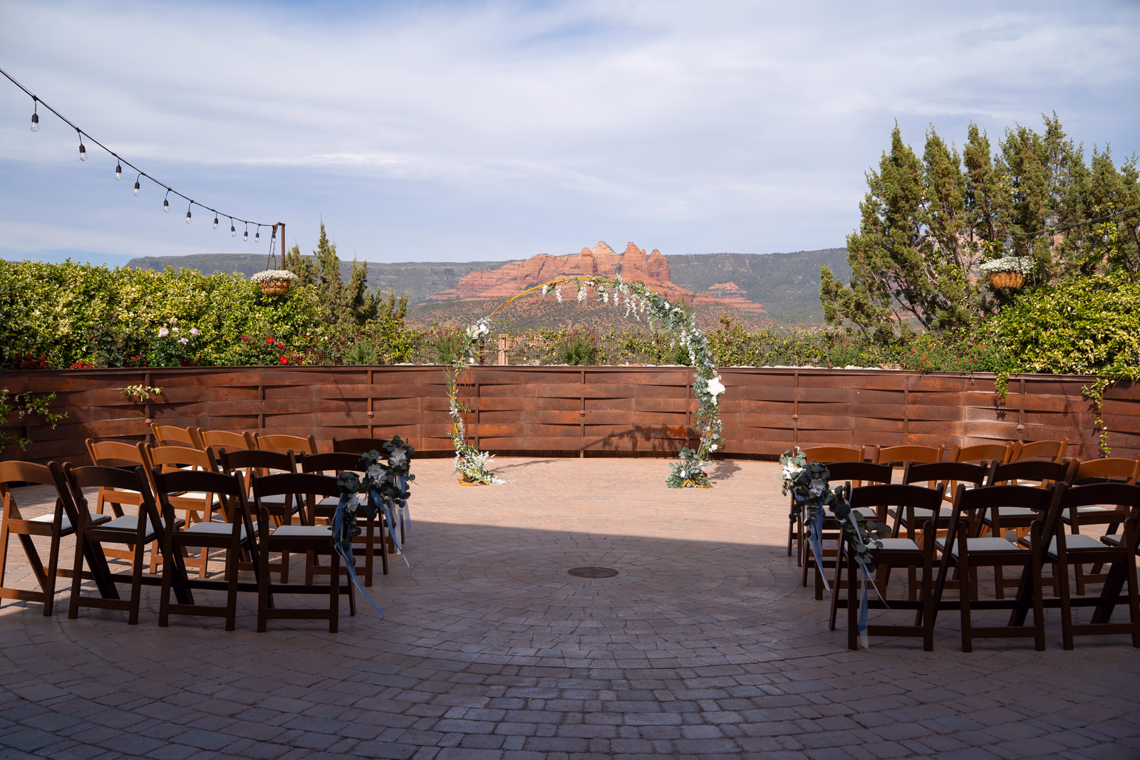 Outdoor wedding ceremony seating and a floral arch with Sedona red-rock views