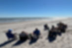 People seated in folding chairs on a sunny beach facing the ocean during a CNIT training in Stone Harbor.