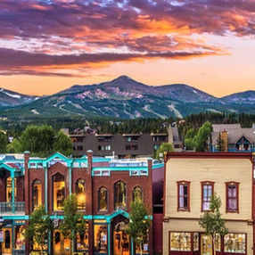 A sunset with Main Street in the foreground and mountains in the background