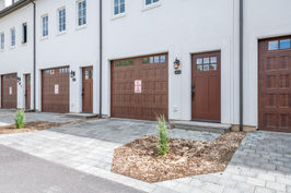Condo Exterior Entrance with patio paver walkway and parking area in front of garage
