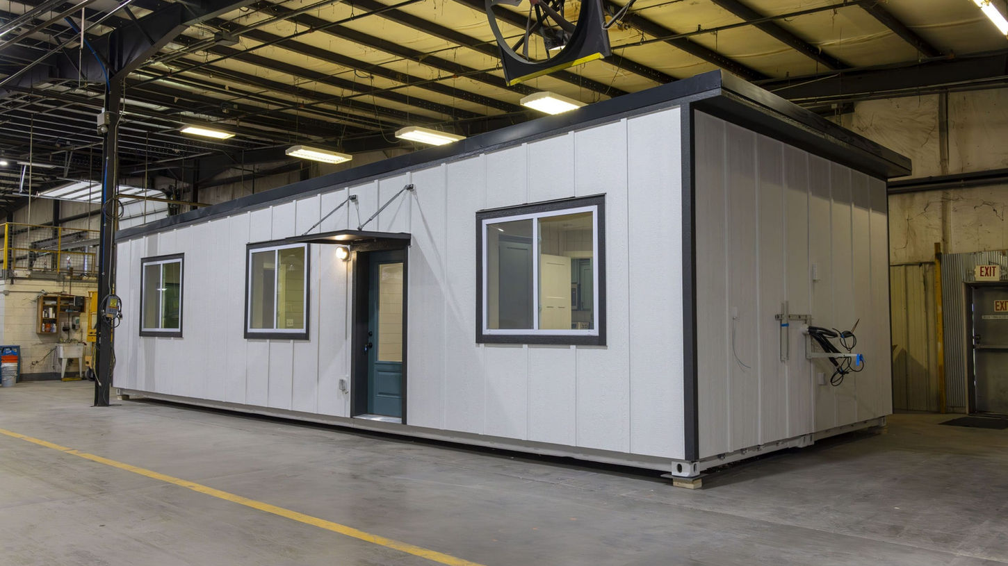 buy container house online with dark door inside industrial warehouse.