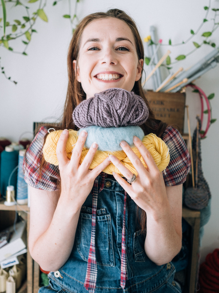 White Woman holding 3 Knitting Wool Balls