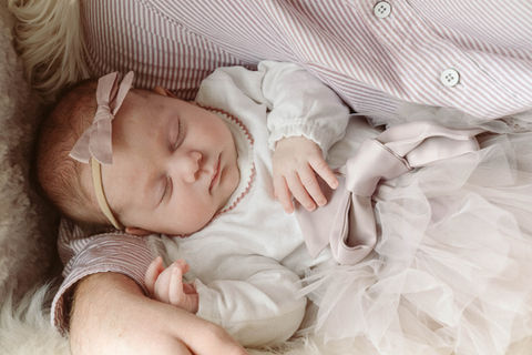 Newborn baby sleeping in dad's arms
