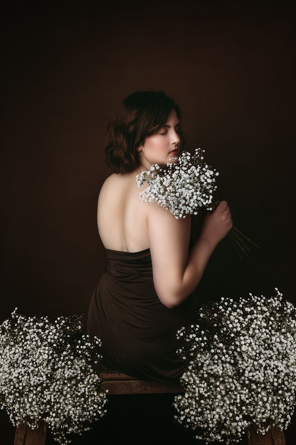 model holding small white flowers