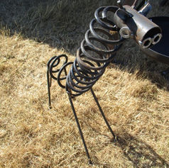 Handcrafted abstract metal garden sculpture with a coiled body, made from reclaimed materials by The Welding Carpenter in Kent