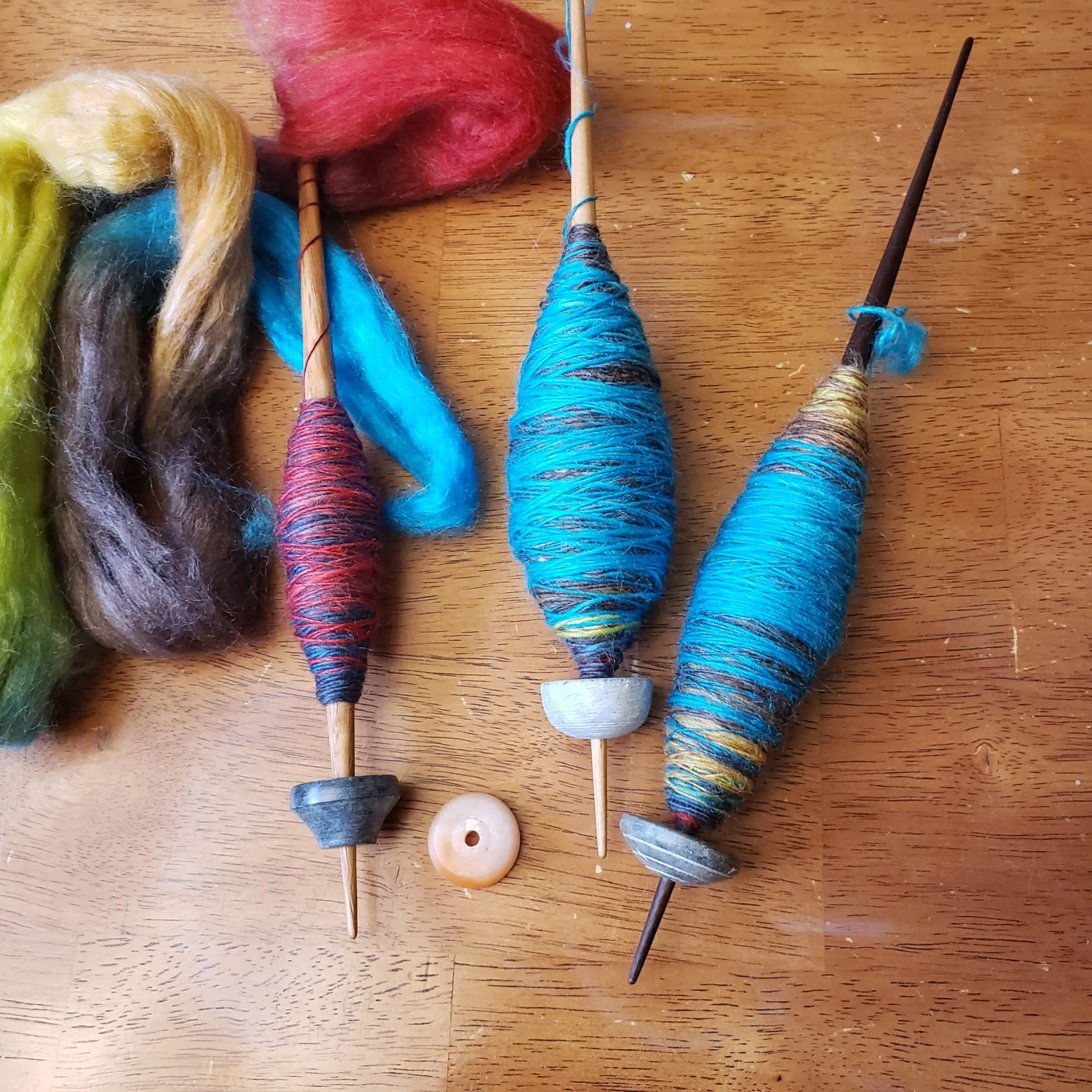 blue, red and gold fleece and spindles with the wrapped thread