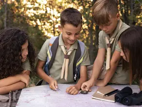 Group of kids at summer camp reading a map together outdoors – representing the best summer camp in Pembroke Pines