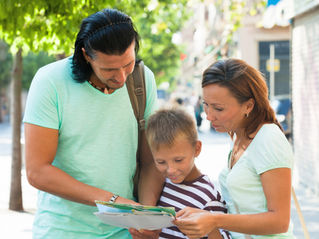Parents reviewing documents with their child outdoors, representing the process to apply for ELC Childcare Funding and plan childcare support.