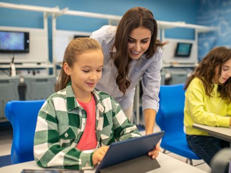A Teacher guides a young student using a tablet during a technology-based learning session at preschools in Pembroke Pines