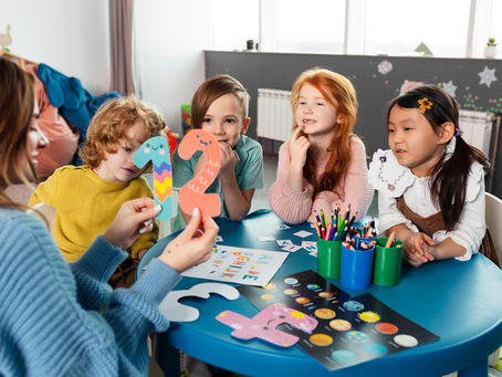 Teacher showing number cards to young children during a learning activity, representing quality Daycares for 3-Year-Olds in Pembroke Pines focused on early education.