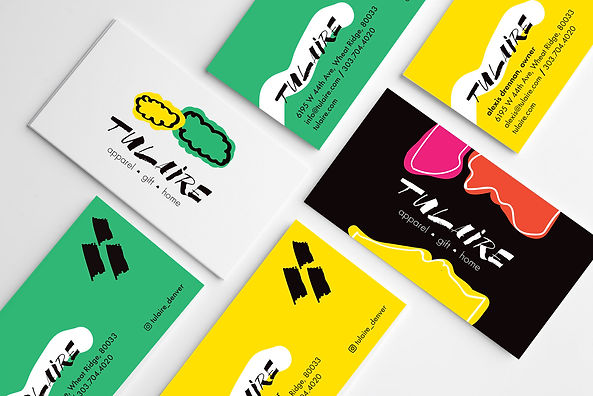 A mockup of the Tulaire business cards (2 designs). One store was the general card for the store that featured a green background with the Tulaire logo in black inside of a white organic shape and the store details underneath and black brushstrokes in the top right corner. On the back the background was all white with organically shaped green and yellow clouds and the logo in black underneath. On Alexis' owner card, the front background is bright yellow with the same logo/text layout as the store card. The back has an all black background with three organic shapes in pink, orange and yellow on top and bottom with the Tulaire logo in the center in white.