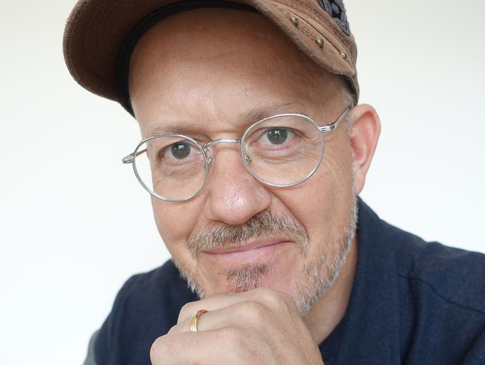 Der Mann mit Brille und Kappe, Philippe Nauer, lächelt freundlich in die Kamera.