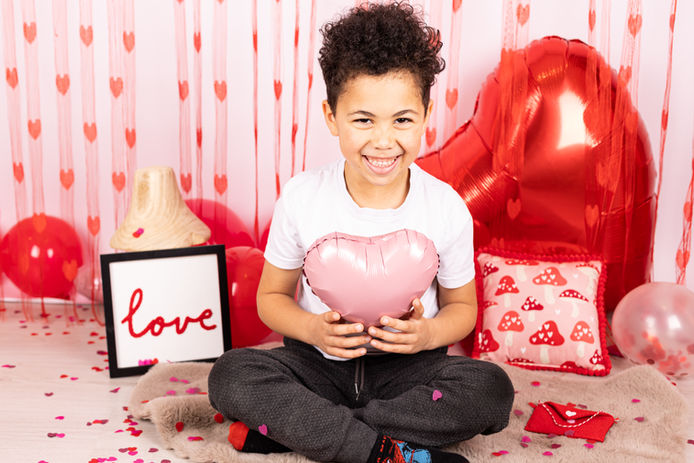 Boy holding pink heart