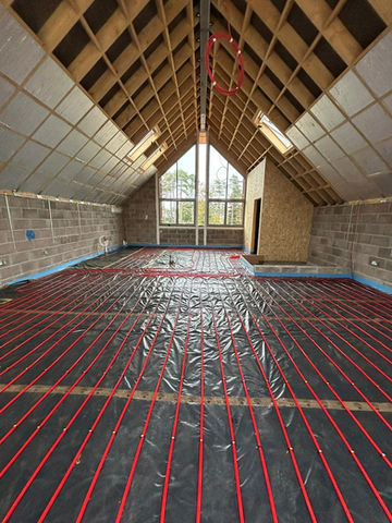 Underfloor heating pipes installed over waterproof sheet