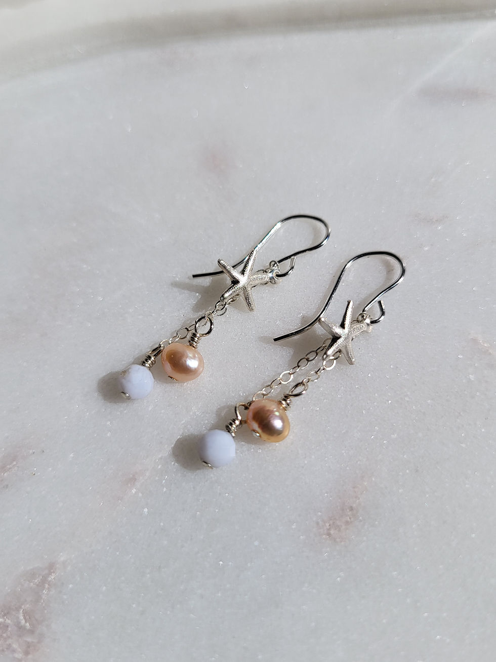 Thumbnail: Sterling silver chain dangle earrings with silver starfish, faceted blue lace agate gemstones, and pink freshswater pearls