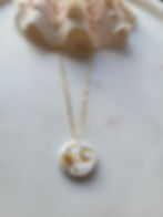 Gold chain necklace featuring a hand painted circular ceramic pendant depicting a gold crescent moon and sun with stars