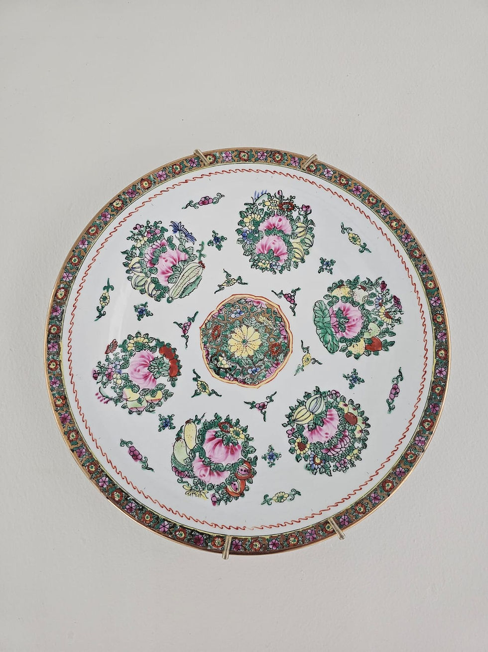 Prato decorativo de parede em porcelana, com design elegante e colorido, apresentando um padrão floral delicado e detalhes em relevo, ideal para embelezar ambientes e adicionar um toque de sofisticação à decoração