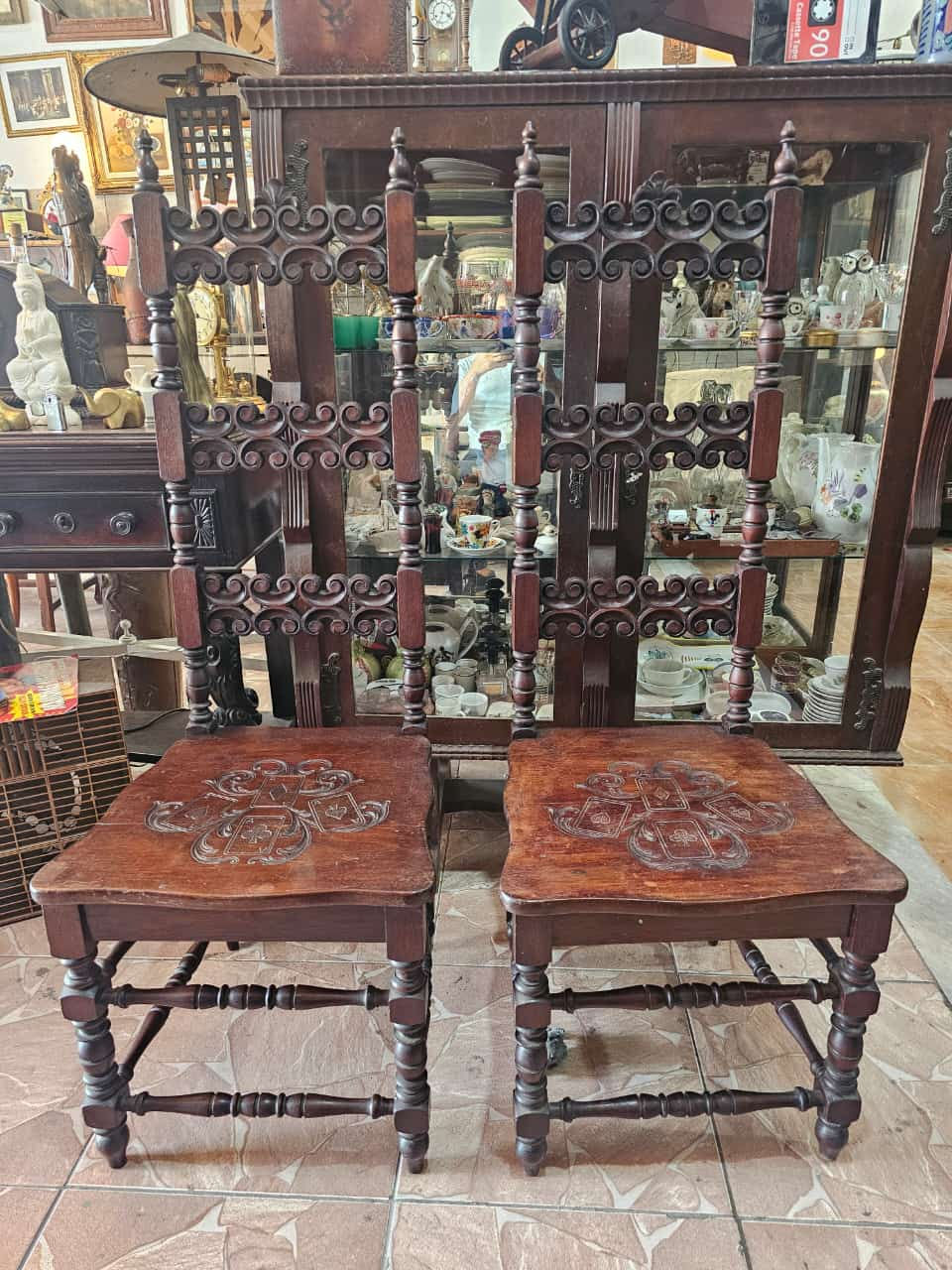 Uma elegante cadeira colonial de madeira escura, com detalhes entalhado perfeita para adicionar um toque de charme vintage a qualquer ambiente. Ideal para colecionadores e amantes de antiguidades
