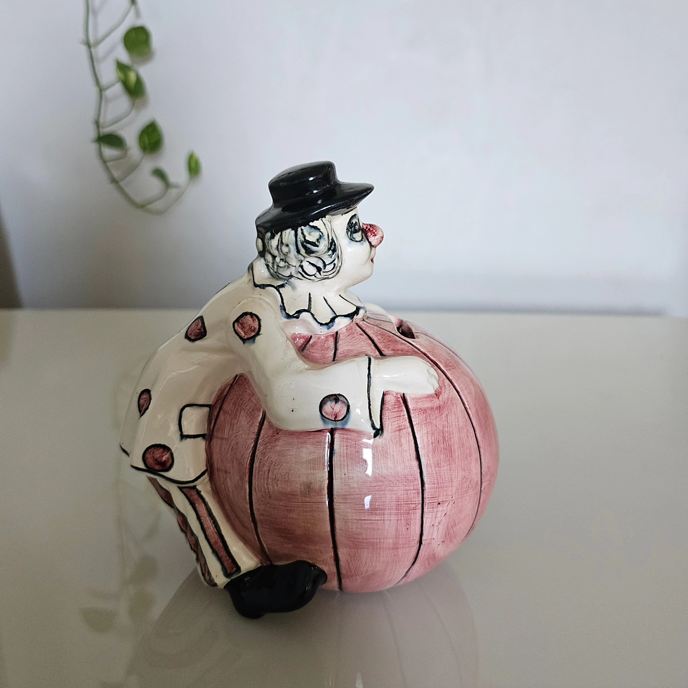 Thumbnail: "Antigo cofre dos anos 60, com figura de palhaço sobre bola em porcelana, exalando charme vintage. A peça apresenta um design único e detalhado, ideal para colecionadores de itens nostálgicos. Perfeita para adicionar um toque de diversão e história à decoração, sendo um excelente exemplar de antiguidade."