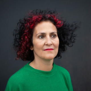Benita headshot green top look up hair b