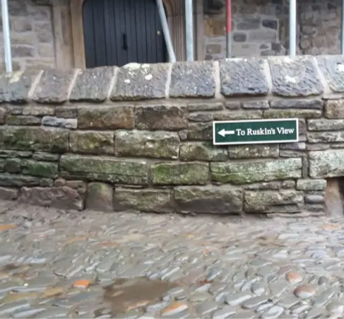 Stone wall with a green sign on it_edite