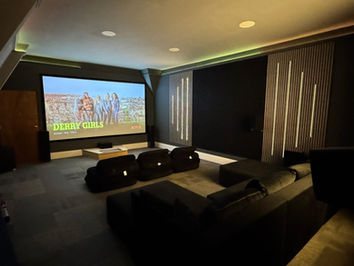 Modern home theater showing 'Dukhi Gali' with acoustic panels and sofas.
