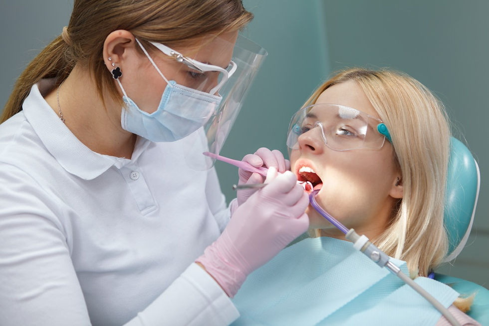 young-woman-wearing-protective-glasses-while-dentist-examining-her-teeth.jpg