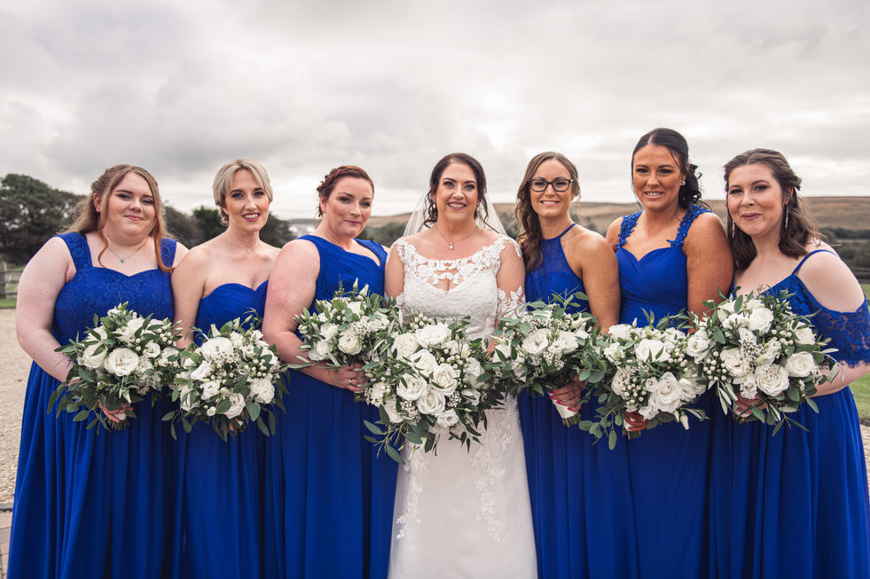 The bride with her bridesmaids in blue dresses at a wedding at Fairyhill, Gower, photographed by Swansea Wedding Photographer Katy Tainton Photography