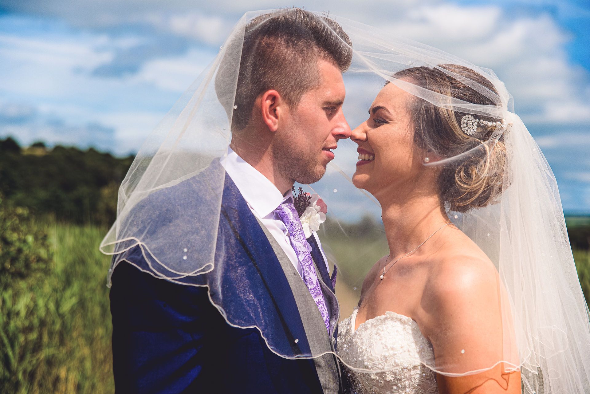 The bride and groom are under the bride's veil at a wedding at the Towers Hotel, Swansea, by Swansea wedding photographer Katy Tainton Photography