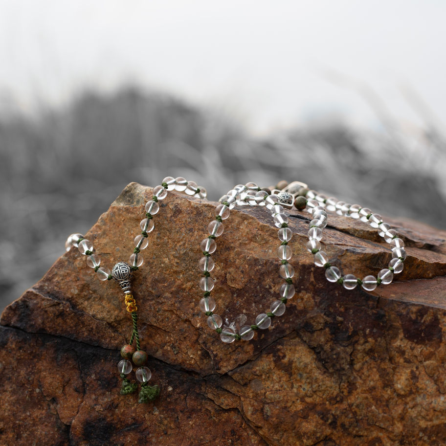 Clear quartz mala beads on rock