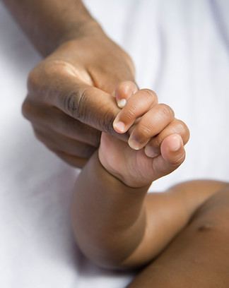 A closeup of a Mother holding her newborn baby's hand.