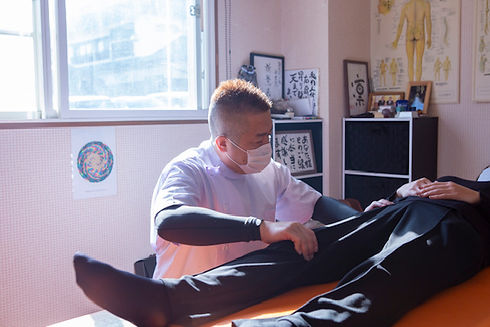 整体院で脚の動きを確認しながら施術を行っている様子