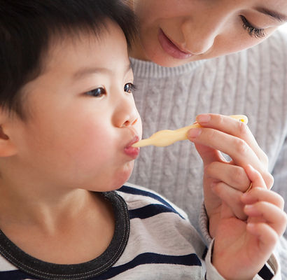 子どもの歯磨きを手伝う母親